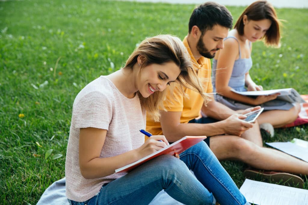 students teenagers casual outfits with note books are studying outdoors